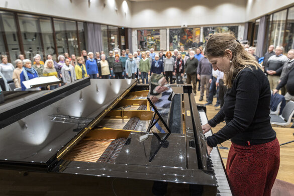 Ein Chor probt mit der Dirigentin am Klavier