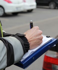 Polizist stellt einen Bußgeldbescheid aus.